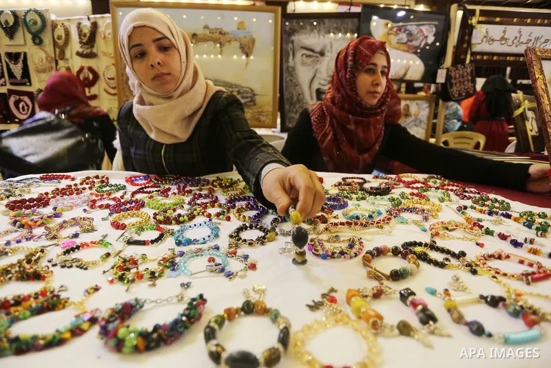Palestinian women take part during Palestinian Heritage Exhibition on the theme ''Products of our women'', in Gaza City, on March 15, 2016. Photo by Mohammed Asad