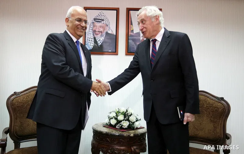Palestinian negotiator Saeb Erakat (L) shakes hand with France's special envoy for its initiative to renew Israeli-Palestinian peace talks, Pierre Vimont during a meeting to present Paris' plans to advance the peace proc...