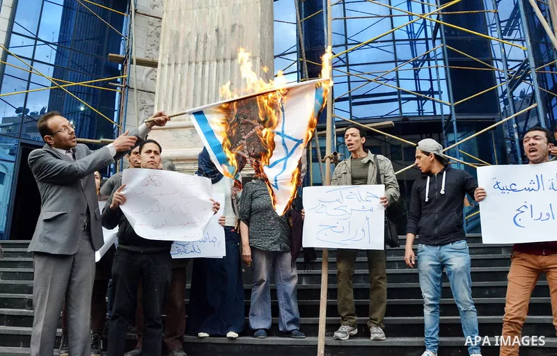 An Egyptian man burn Israeli flag during a protest aginst French company Orange in front of journalists syndicate in Cairo, Egypt March 15, 2016. French company Orange has announced the change of its company name in Egyp...