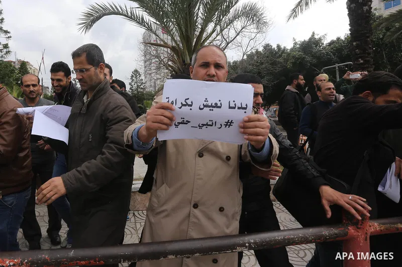 Employees of former Palestinian government take part in a protest to demand for pay their salaries, in Gaza city on March 16, 2016. Photo by Mohammed Asad