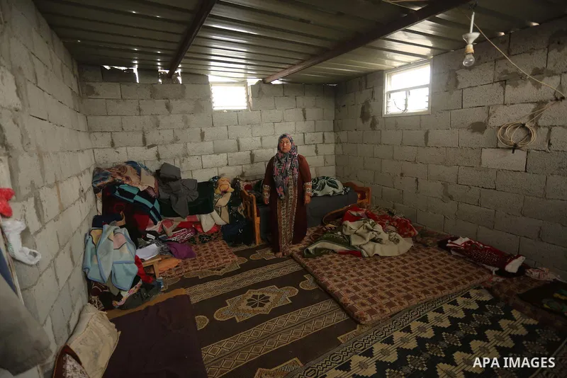 Palestinian woman Jihan Abu Muhsen stands inside her dwelling before going to work collecting bricks for sale from the sites of demolished buildings in Khan Younis in the southern Gaza Strip March 17, 2016. Abu Muhsen ga...