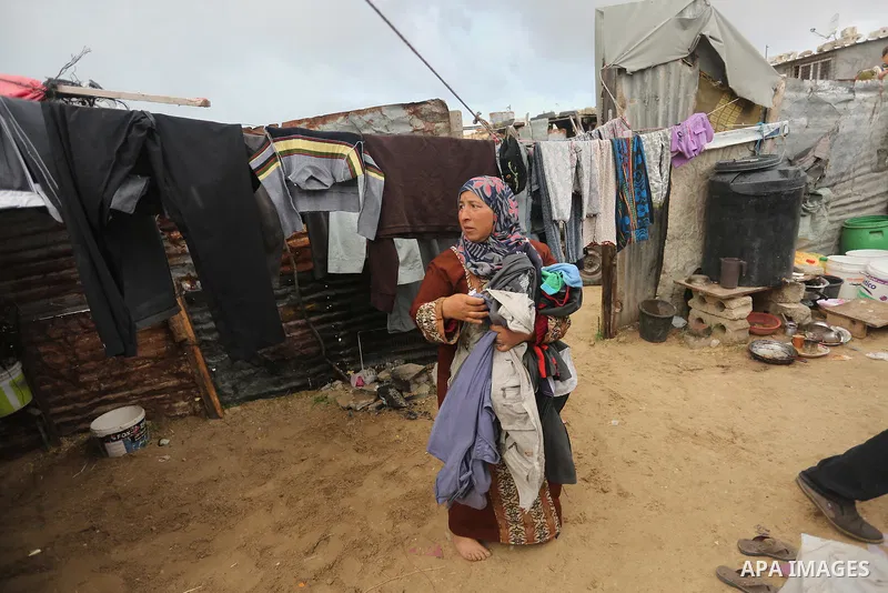 Palestinian woman Jihan Abu Muhsen collects bricks for sale with her son Mohammad from the ruins of a house destroyed during the 2014 war in Khan Younis in the southern Gaza Strip March 17, 2016. Abu Muhsen gathers brick...