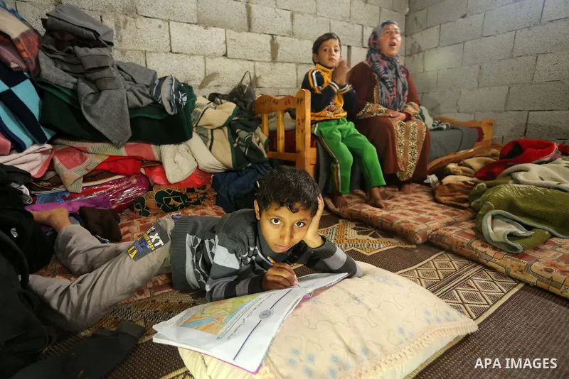 Palestinian woman Jihan Abu Muhsen sits inside her dwelling before going to work collecting bricks for sale from the sites of demolished buildings in Khan Younis in the southern Gaza Strip March 17, 2016. Abu Muhsen gath...