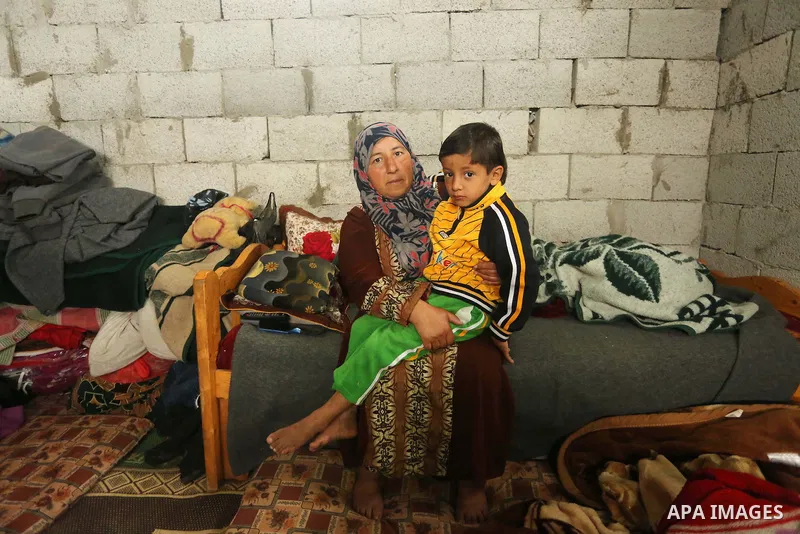 Palestinian woman Jihan Abu Muhsen sits inside her dwelling before going to work collecting bricks for sale from the sites of demolished buildings in Khan Younis in the southern Gaza Strip March 17, 2016. Abu Muhsen gath...