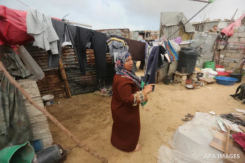 Palestinian woman Jihan Abu Muhsen stands outside her dwelling before going to work collecting bricks for sale from the sites of demolished buildings in Khan Younis in the southern Gaza Strip March 17, 2016. Abu Muhsen g...