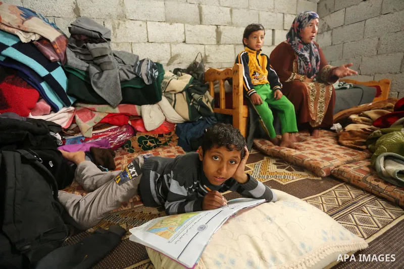 Palestinian woman Jihan Abu Muhsen sits inside her dwelling before going to work collecting bricks for sale from the sites of demolished buildings in Khan Younis in the southern Gaza Strip March 17, 2016. Abu Muhsen gath...