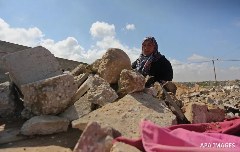 Palestinian woman Jihan Abu Muhsen collects bricks for sale with her son Mohammad from the ruins of a house destroyed during the 2014 war in Khan Younis in the southern Gaza Strip March 17, 2016. Abu Muhsen gathers brick...