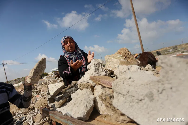 Palestinian woman Jihan Abu Muhsen collects bricks for sale with her son Mohammad from the ruins of a house destroyed during the 2014 war in Khan Younis in the southern Gaza Strip March 17, 2016. Abu Muhsen gathers brick...