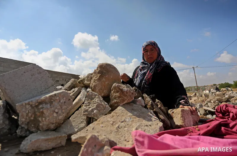 Palestinian woman Jihan Abu Muhsen collects bricks for sale with her son Mohammad from the ruins of a house destroyed during the 2014 war in Khan Younis in the southern Gaza Strip March 17, 2016. Abu Muhsen gathers brick...
