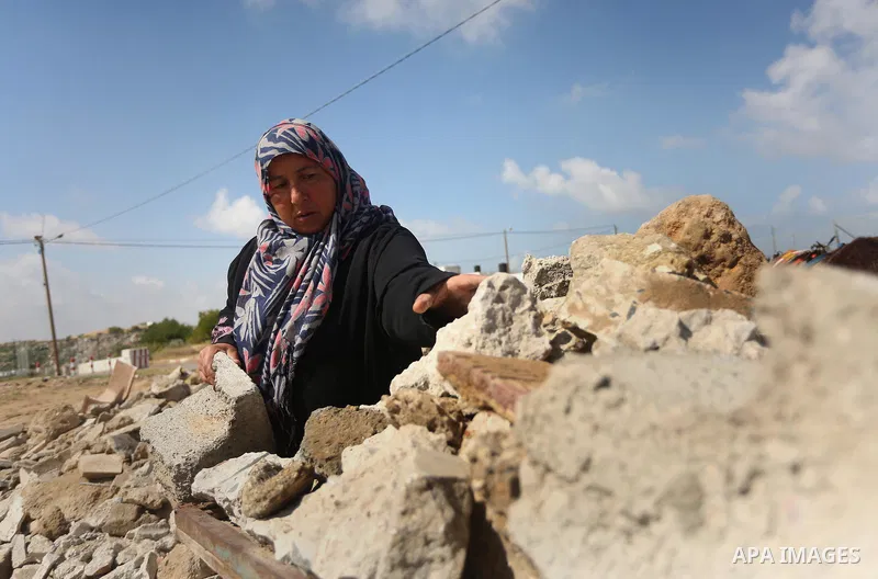 Palestinian woman Jihan Abu Muhsen collects bricks for sale with her son Mohammad from the ruins of a house destroyed during the 2014 war in Khan Younis in the southern Gaza Strip March 17, 2016. Abu Muhsen gathers brick...