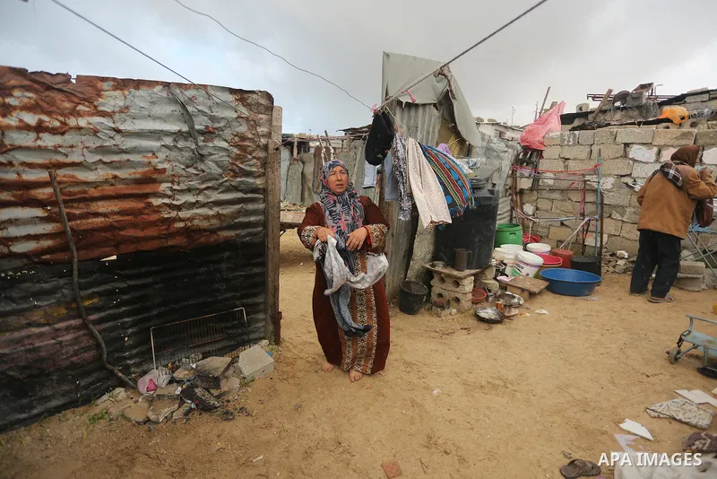 Palestinian woman Jihan Abu Muhsen collects bricks for sale with her son Mohammad from the ruins of a house destroyed during the 2014 war in Khan Younis in the southern Gaza Strip March 17, 2016. Abu Muhsen gathers brick...