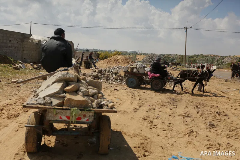 Palestinian woman Jihan Abu Muhsen collects bricks for sale with her son Mohammad from the ruins of a house destroyed during the 2014 war in Khan Younis in the southern Gaza Strip March 17, 2016. Abu Muhsen gathers brick...