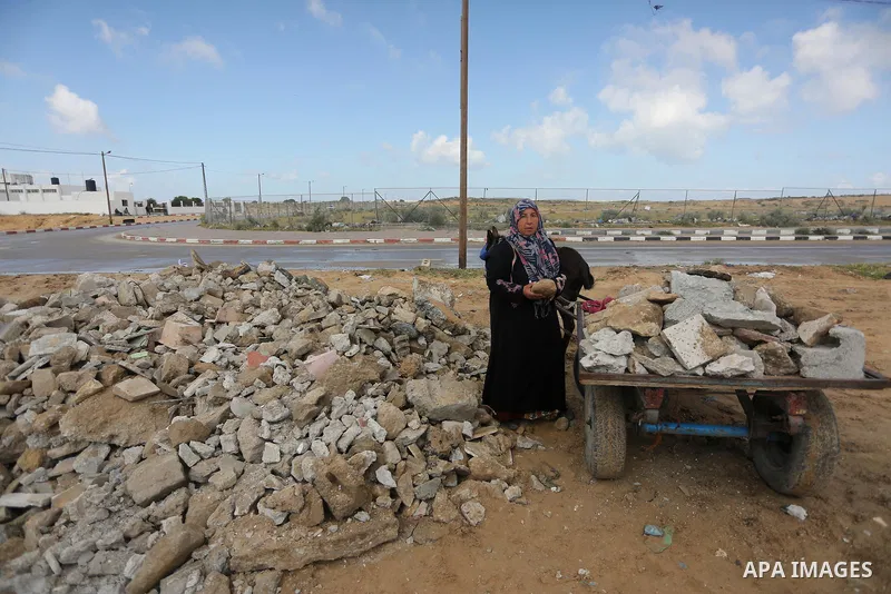 Palestinian woman Jihan Abu Muhsen collects bricks for sale with her son Mohammad from the ruins of a house destroyed during the 2014 war in Khan Younis in the southern Gaza Strip March 17, 2016. Abu Muhsen gathers brick...
