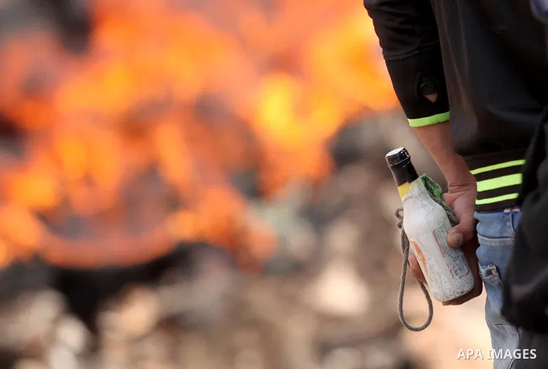 A Palestinian protester carry a molotov cocktail during clashes with Israeli security forces following a demonstration against the expropriation of Palestinian land by Israel in the village of Kfar Qaddum, near Nablus, i...
