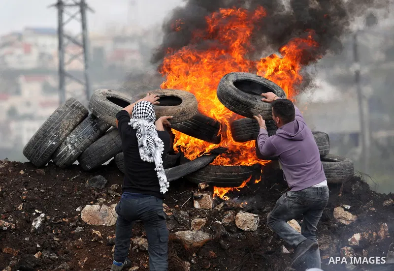 Palestinian protesters burn tires during clashes with Israeli security forces following a demonstration against the expropriation of Palestinian land by Israel in the village of Kfar Qaddum, near Nablus, in the occupied...