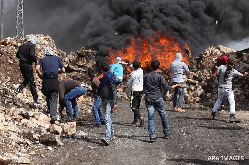 Palestinian protesters hurl stones toward Israeli security forces during clashes following a demonstration against the expropriation of Palestinian land by Israel in the village of Kfar Qaddum, near Nablus, in the occupi...