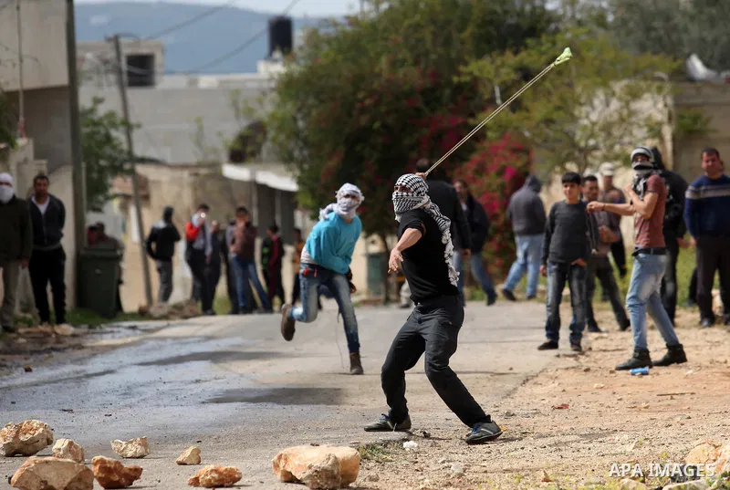 Palestinian protesters hurl stones toward Israeli security forces during clashes following a demonstration against the expropriation of Palestinian land by Israel in the village of Kfar Qaddum, near Nablus, in the occupi...