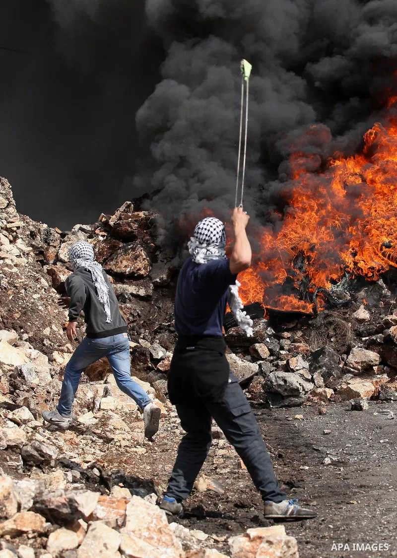 Palestinian protesters hurl stones toward Israeli security forces during clashes following a demonstration against the expropriation of Palestinian land by Israel in the village of Kfar Qaddum, near Nablus, in the occupi...