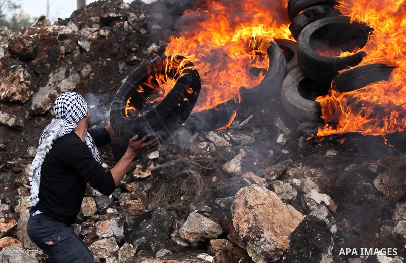 Palestinian protesters burn tires during clashes with Israeli security forces following a demonstration against the expropriation of Palestinian land by Israel in the village of Kfar Qaddum, near Nablus, in the occupied...