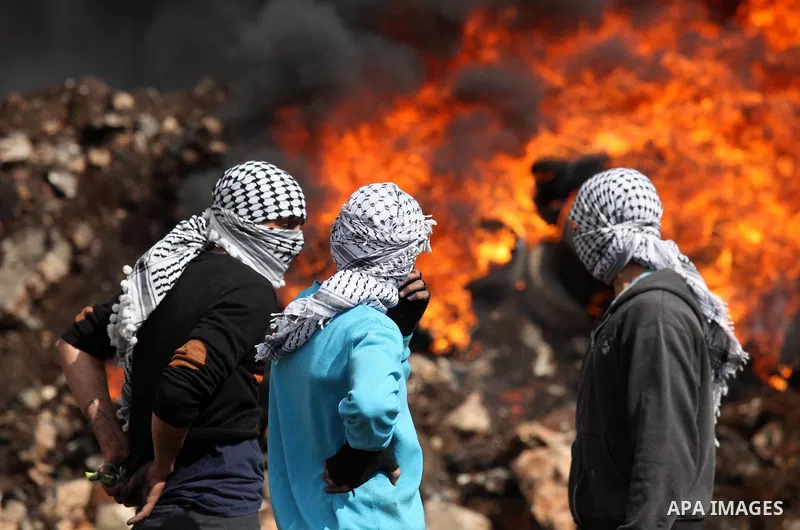 Palestinian protesters look on during clashes Israeli security forces following a demonstration against the expropriation of Palestinian land by Israel in the village of Kfar Qaddum, near Nablus, in the occupied West Ban...