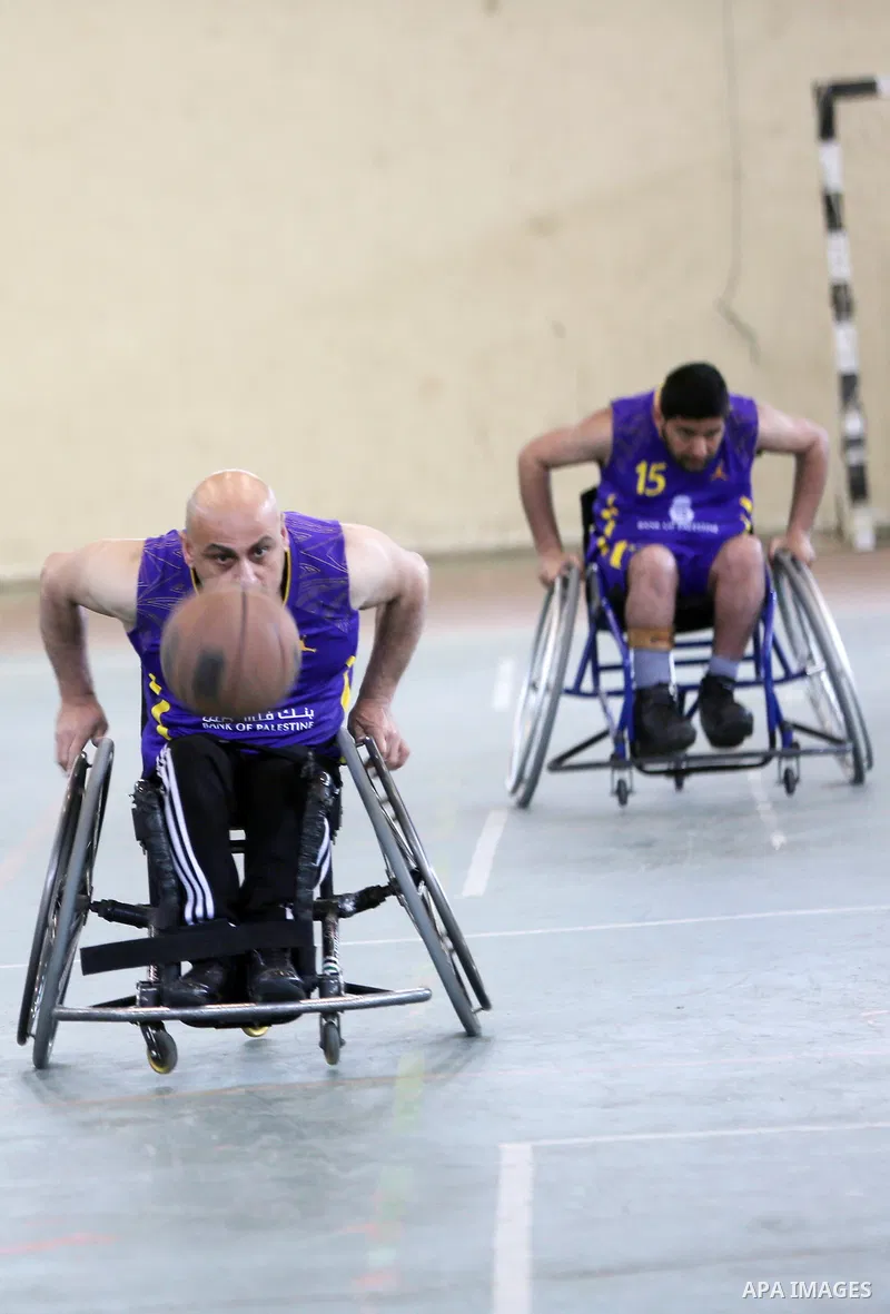 Disabled Palestinians from West Bank and Gaza play a friendly basketball match in the West Bank city of Ramallah on March 18, 2016. Photo by Shadi Hatem