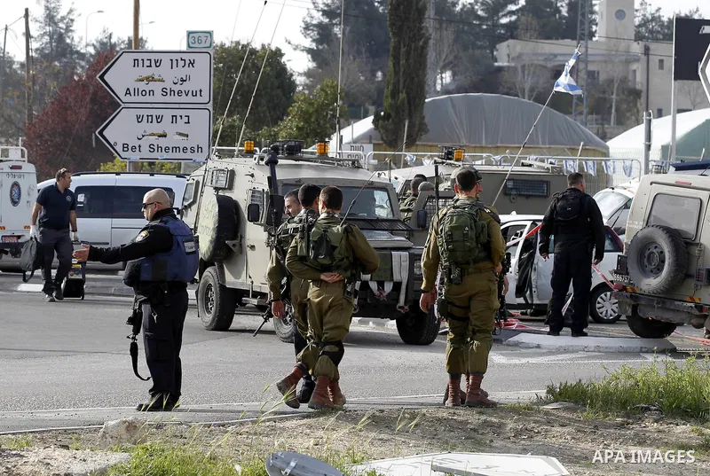 Israeli security forces inspect the scene where a Palestinian, who the Israeli military said tried to stab soldiers, was shot dead at Gush Etzion junction, south of the West Bank city of Bethlehem March 18, 2016. Photo b...
