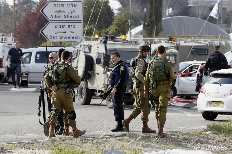 Israeli security forces inspect the scene where a Palestinian, who the Israeli military said tried to stab soldiers, was shot dead at Gush Etzion junction, south of the West Bank city of Bethlehem March 18, 2016. Photo b...