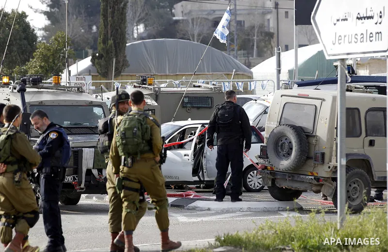 Israeli security forces inspect the scene where a Palestinian, who the Israeli military said tried to stab soldiers, was shot dead at Gush Etzion junction, south of the West Bank city of Bethlehem March 18, 2016. Photo b...
