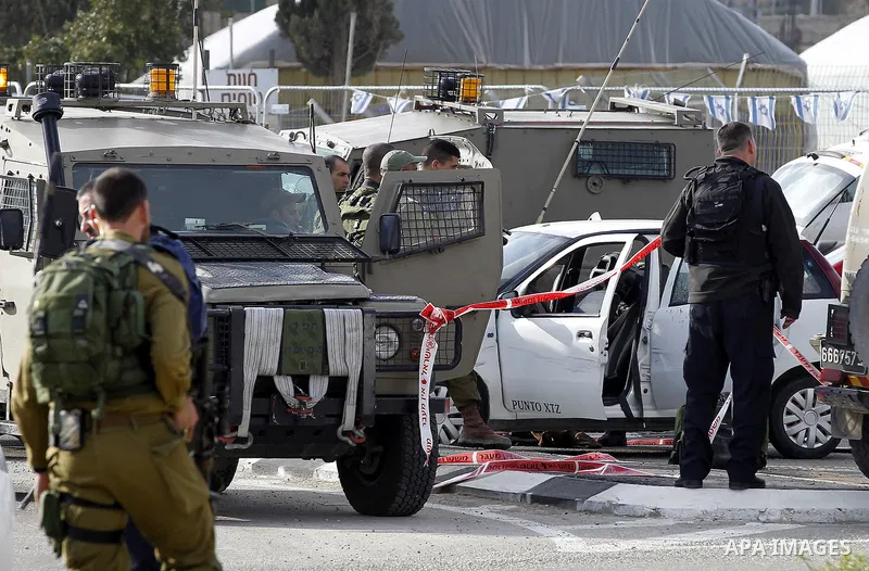 Israeli security forces inspect the scene where a Palestinian, who the Israeli military said tried to stab soldiers, was shot dead at Gush Etzion junction, south of the West Bank city of Bethlehem March 18, 2016. Photo b...