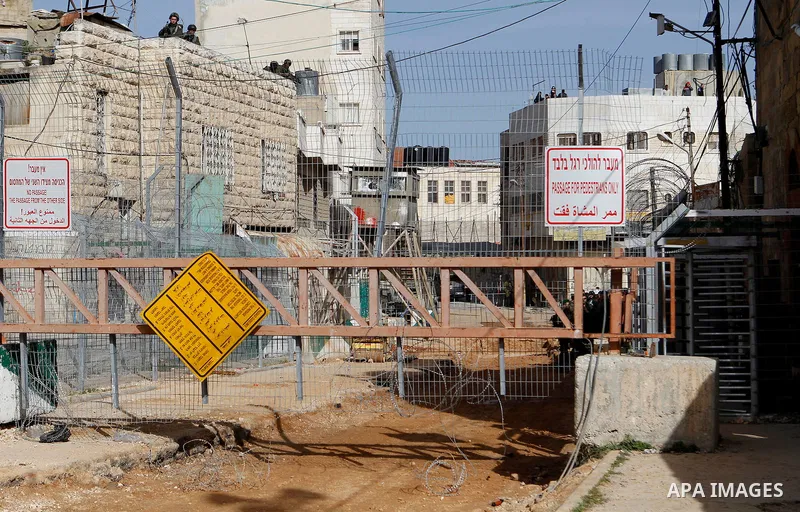 Israeli security forces gather near the scene where a Palestinian youth was shot near the Ibrahimi mosque, or the Tomb of the Patriarch, a religious site to both Muslims and Jews, in the Israeli occupied West Bank city o...