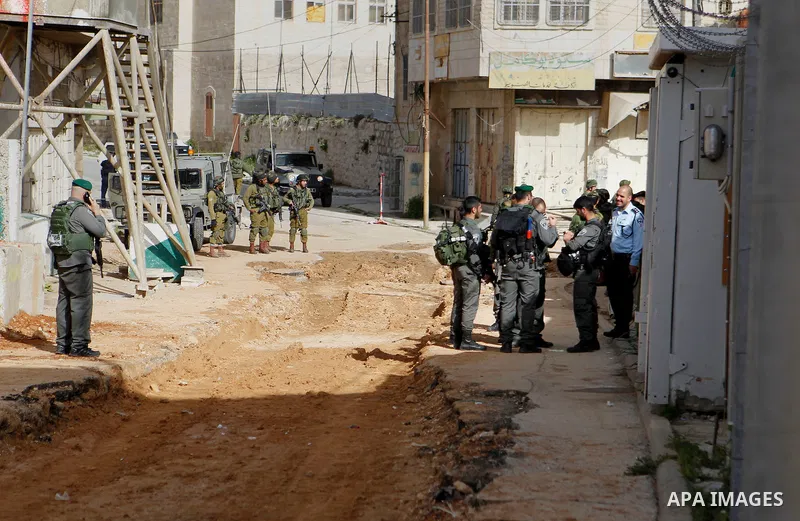 Israeli security forces gather near the scene where a Palestinian youth was shot near the Ibrahimi mosque, or the Tomb of the Patriarch, a religious site to both Muslims and Jews, in the Israeli occupied West Bank city o...