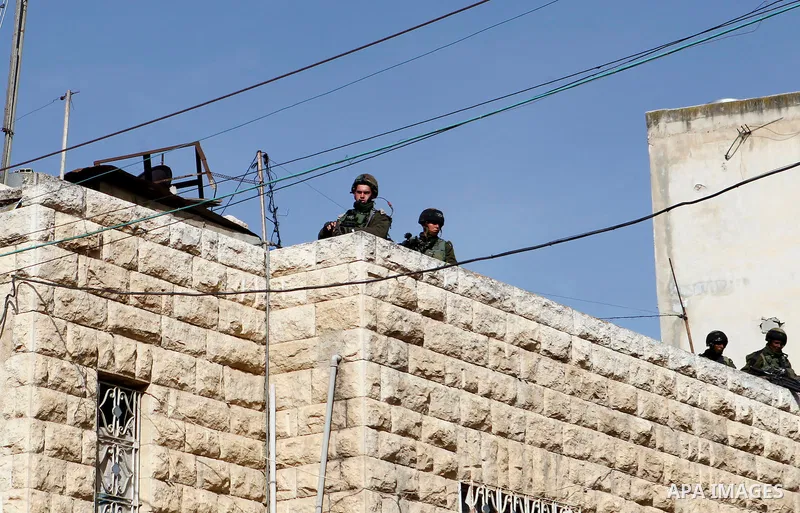 Israeli security forces gather near the scene where a Palestinian youth was shot near the Ibrahimi mosque, or the Tomb of the Patriarch, a religious site to both Muslims and Jews, in the Israeli occupied West Bank city o...