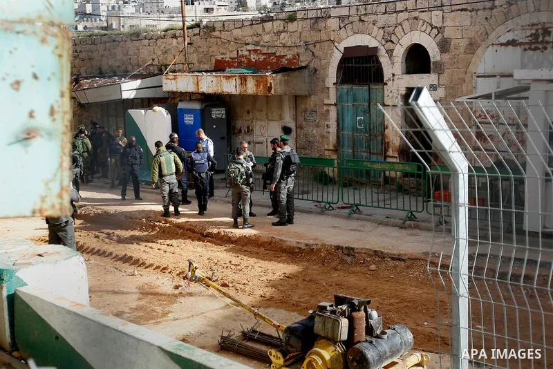 Israeli security forces gather near the scene where a Palestinian youth was shot near the Ibrahimi mosque, or the Tomb of the Patriarch, a religious site to both Muslims and Jews, in the Israeli occupied West Bank city o...