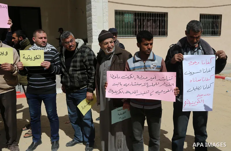 Palestinians who beneficiaries from Kuwaiti grant hold placards during a protest demanding to reconstruction of their homes which destroyed during 2014 war in Gaza city on March 20, 2016. Photo by Mohammed Asad