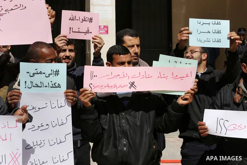 Palestinians who beneficiaries from Kuwaiti grant hold placards during a protest demanding to reconstruction of their homes which destroyed during 2014 war in Gaza city on March 20, 2016. Photo by Mohammed Asad