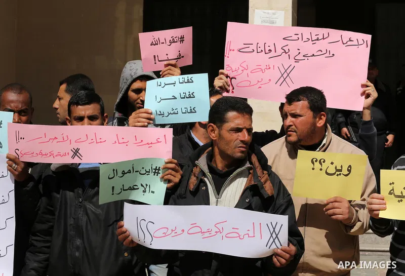 Palestinians who beneficiaries from Kuwaiti grant hold placards during a protest demanding to reconstruction of their homes which destroyed during 2014 war in Gaza city on March 20, 2016. Photo by Mohammed Asad