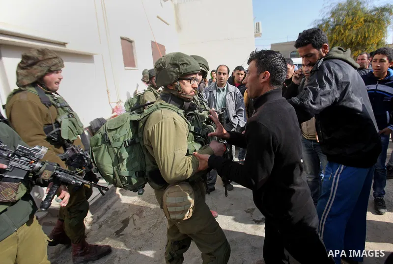 Israeli soldiers scuffle with a Palestinian man near the house of Ibrahim Dawabsheh, the main witness in the July arson attack that killed a Palestinian family, in the Israeli occupied West Bank village of Duma near Nabl...