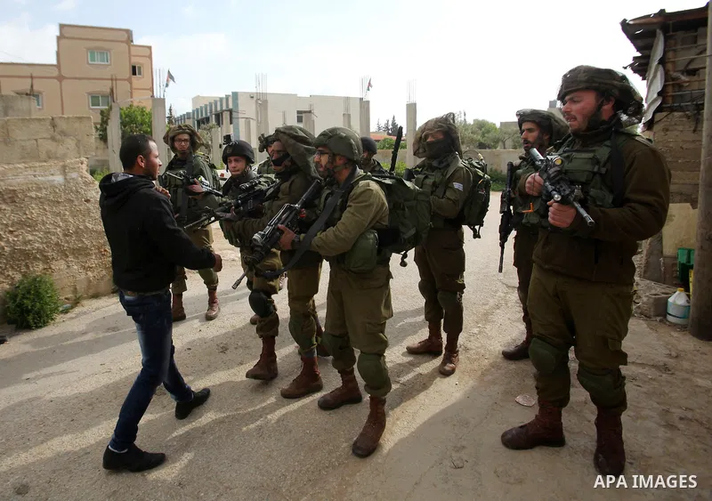 Israeli soldiers scuffle with a Palestinian man near the house of Ibrahim Dawabsheh, the main witness in the July arson attack that killed a Palestinian family, in the Israeli occupied West Bank village of Duma near Nabl...