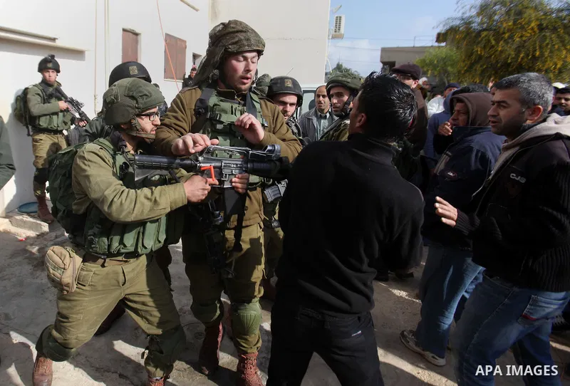 Israeli soldiers scuffle with a Palestinian man near the house of Ibrahim Dawabsheh, the main witness in the July arson attack that killed a Palestinian family, in the Israeli occupied West Bank village of Duma near Nabl...