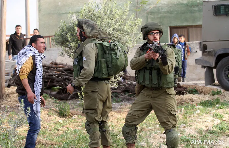 Israeli soldiers scuffle with a Palestinian man near the house of Ibrahim Dawabsheh, the main witness in the July arson attack that killed a Palestinian family, in the Israeli occupied West Bank village of Duma near Nabl...