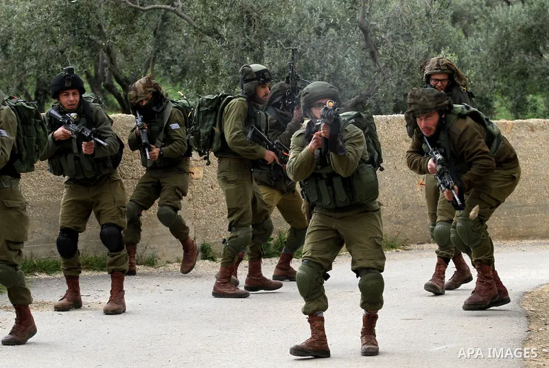 Israeli security forces stand guard outside a Palestinian burnt-out house belonging to a key witness to an arson attack which took place last year by Jewish extremists that killed a Palestinian family, in the Israeli occ...