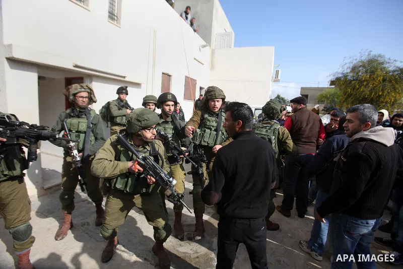 Israeli soldiers scuffle with a Palestinian man near the house of Ibrahim Dawabsheh, the main witness in the July arson attack that killed a Palestinian family, in the Israeli occupied West Bank village of Duma near Nabl...
