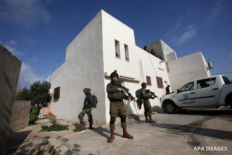 Israeli security forces stand guard outside a Palestinian burnt-out house belonging to a key witness to an arson attack which took place last year by Jewish extremists that killed a Palestinian family, in the Israeli occ...