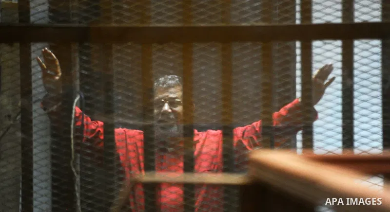 Ousted Egyptian president Mohammed Morsi sits behind bars during his trail as part of the so-called 'Qatar espionage' case, in a court in Cairo on March 21, 2016. The defendants are accused of 'leaking important national...