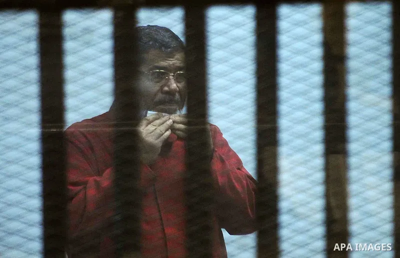 Ousted Egyptian president Mohammed Morsi sits behind bars during his trail as part of the so-called 'Qatar espionage' case, in a court in Cairo on March 21, 2016. The defendants are accused of 'leaking important national...
