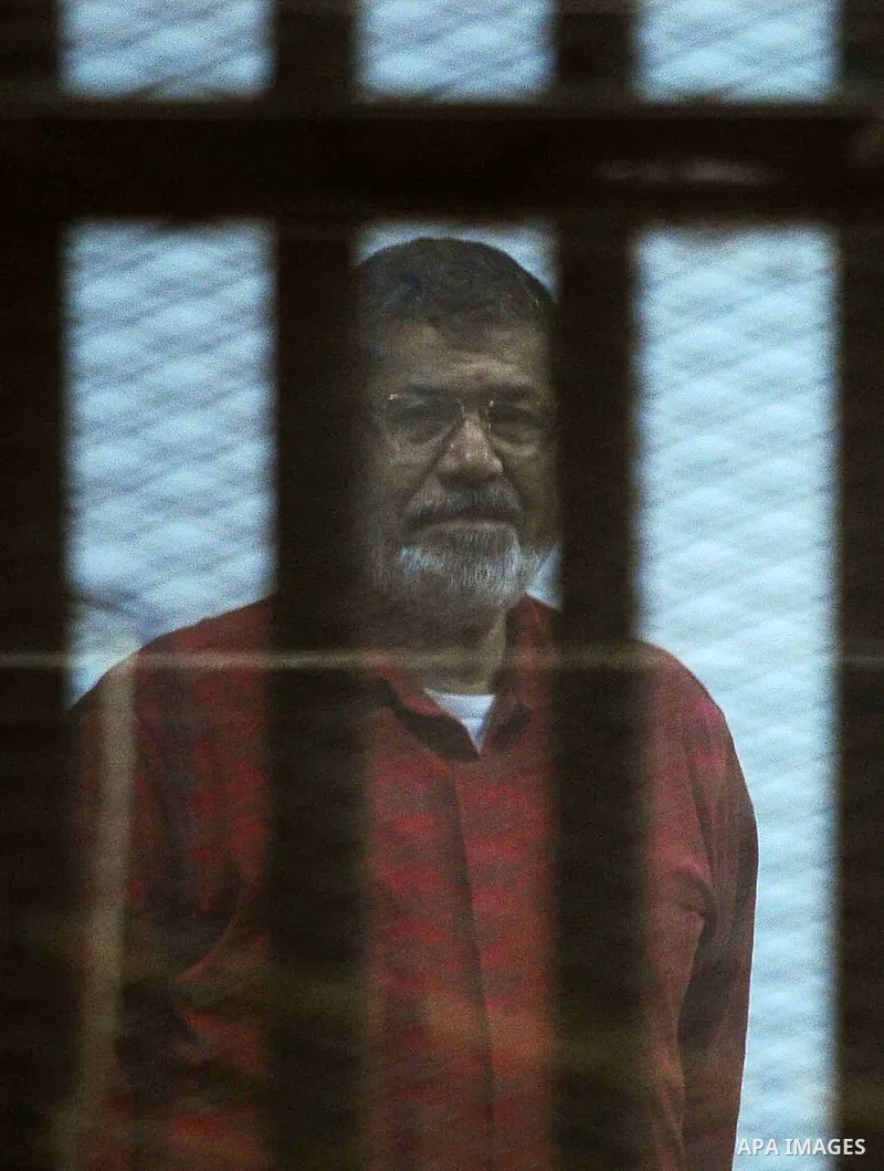 Ousted Egyptian president Mohammed Morsi sits behind bars during his trail as part of the so-called 'Qatar espionage' case, in a court in Cairo on March 21, 2016. The defendants are accused of 'leaking important national...