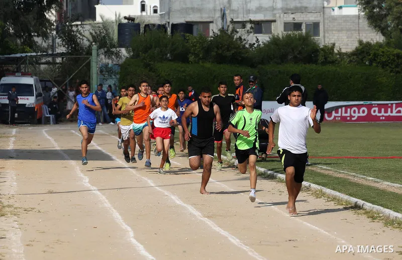 Palestinian youths take part in a local running championship at Yarmouk Stadium in Gaza city on March 21, 2016. Photo by Mohammed Asad