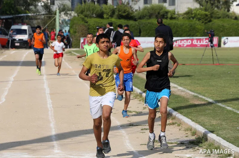 Palestinian youths take part in a local running championship at Yarmouk Stadium in Gaza city on March 21, 2016. Photo by Mohammed Asad