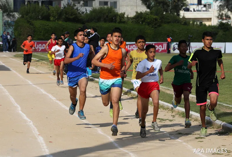 Palestinian youths take part in a local running championship at Yarmouk Stadium in Gaza city on March 21, 2016. Photo by Mohammed Asad