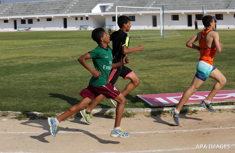 Palestinian youths take part in a local running championship at Yarmouk Stadium in Gaza city on March 21, 2016. Photo by Mohammed Asad
